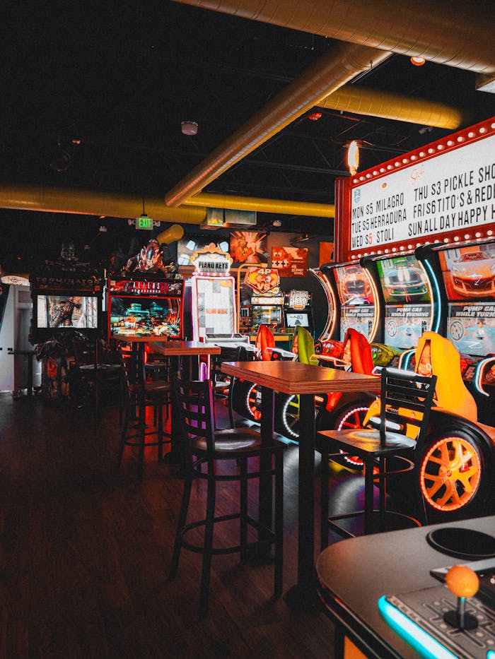 Home Vibrant indoor arcade filled with colorful game machines and empty seats, inviting entertainment.